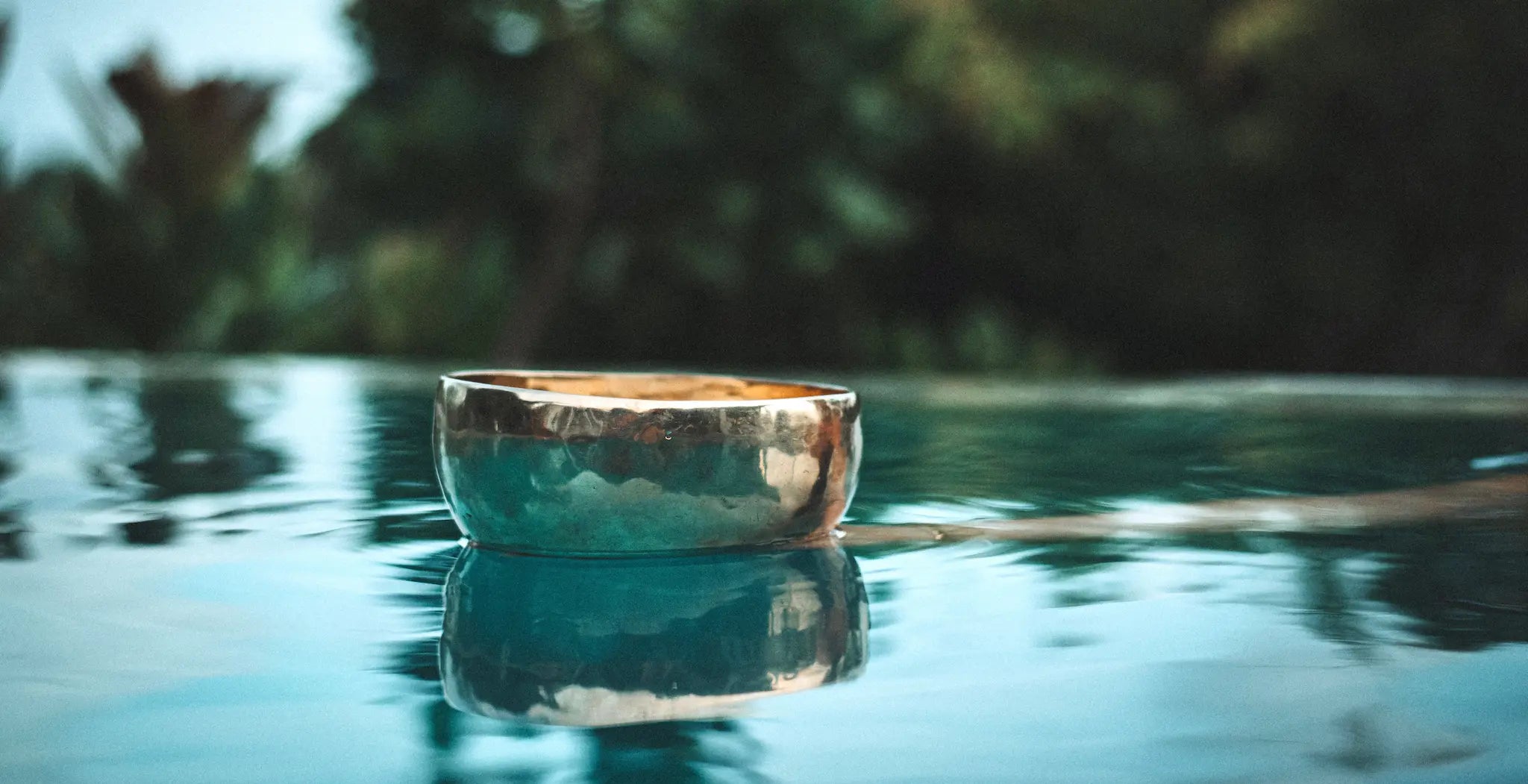 Eine Klangschale von Sonner Sound schwimmt im türkisfarbenen Wasser